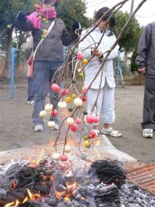 富士見が丘3丁目、松根地区(合同)　木の枝の先につけたダンゴをあぶる様子