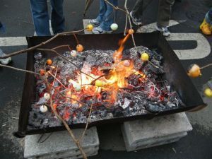 元町南地区　木の枝の先につけたダンゴをあぶる様子