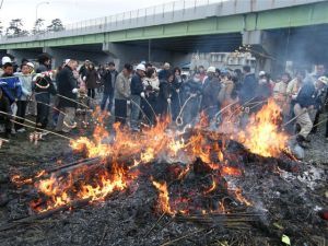 梅沢地区　棒の先につけたダンゴをあぶる様子